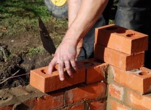 3986916-construction-worker-laying-bricks-wall-of-building